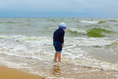 küçük çocuk denizde eğlenir