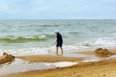 küçük çocuk denizde eğlenir