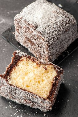 Lezzetli bir lamington, sünger keki, çikolata sosu ve parçalanmış hindistan cevizi.