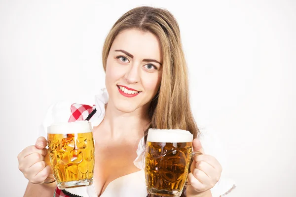 Vrouw poseren in dirndl jurk tegen een witte muur. — Stockfoto