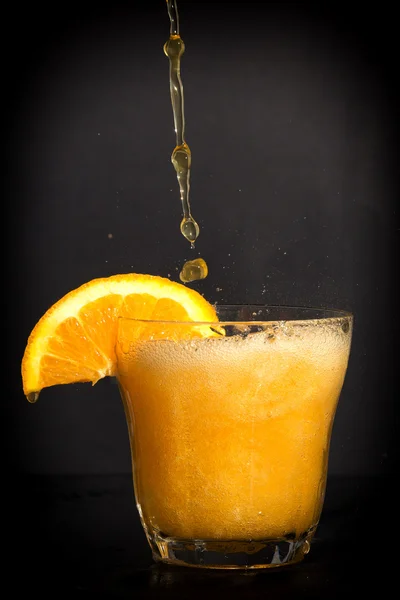 Boisson gazeuse aromatisée à l'orange éclaboussant le verre . — Photo