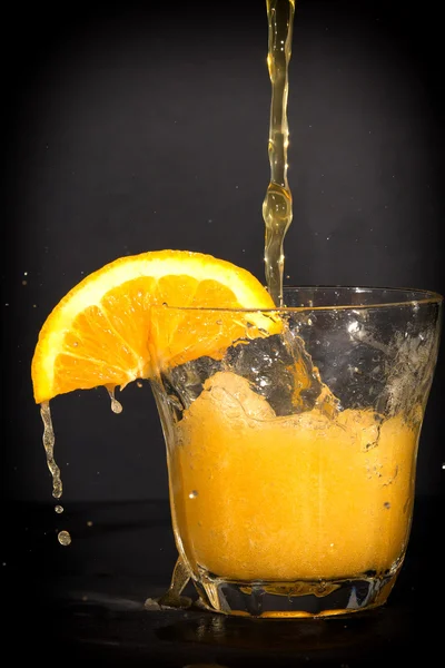 Refresco con sabor a naranja salpicando el vaso . — Foto de Stock