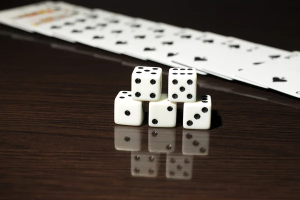 Gaming dice and a row of playing cards. — Stock Photo, Image