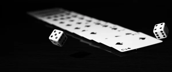 Gaming dice and a row of playing cards. — Stock Photo, Image