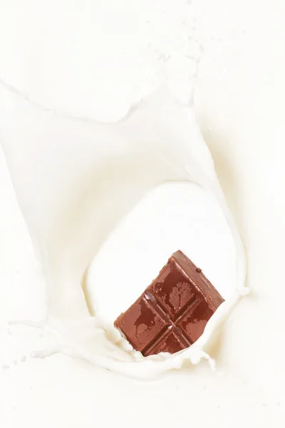 Dark chocolate splashed into milk — Stock Photo, Image