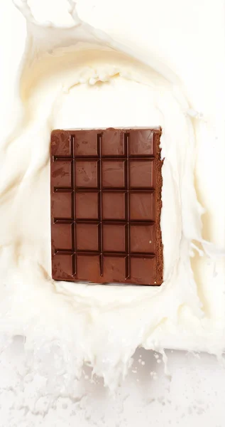 Chocolate escuro salpicado no leite — Fotografia de Stock