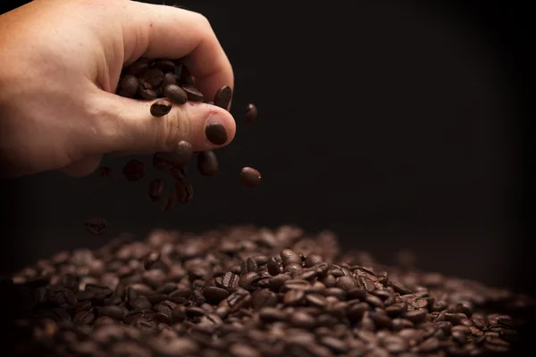 Hand grabbing coffee beans. — Stock Photo, Image