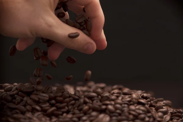 Hand grabbing coffee beans. — Stock Photo, Image