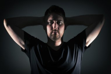 Adam kızgın yüz ve koyu arka plan ile poz