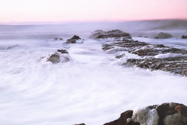 Морская пена на скалах в полдень . — стоковое фото