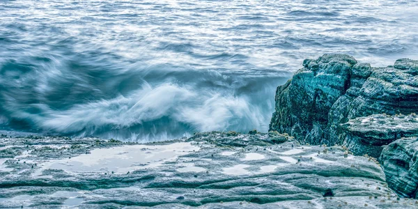 Скалы и волны в Пойнт-Картрайт — стоковое фото
