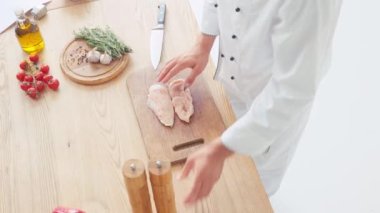 Şefin baharat katma ve pirzola kesme tahtasına tavuk filetosu sürme manzarası