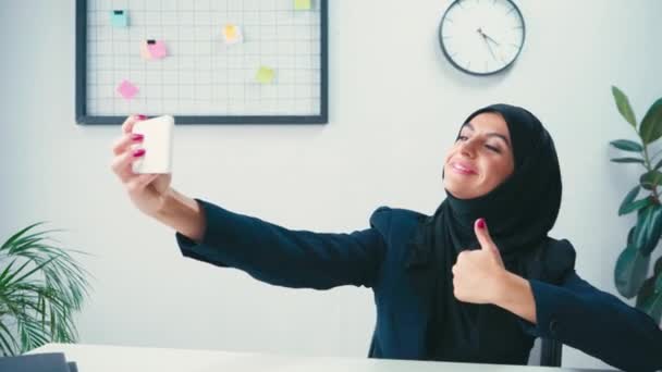 Lächelnde Muslimische Geschäftsfrau Gestikuliert Beim Selfie Mit Dem Smartphone — Stockvideo