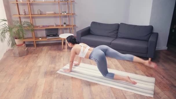 年轻的女运动员在家里的健身垫上做臀部运动 — 图库视频影像