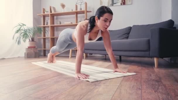 年轻的女运动员在家里的健身垫上做俯卧撑 — 图库视频影像
