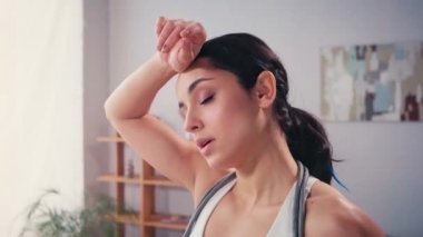 İp atlayan yorgun sporcu kadın evinde su içiyor. 