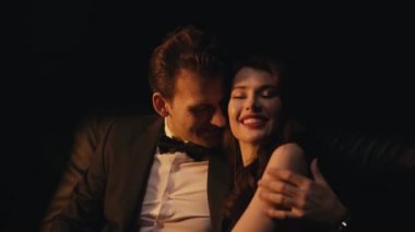 Takım elbiseli, gülümseyen bir adam, siyahların izole edilmiş kız arkadaşına sarılıp flört ediyor. 