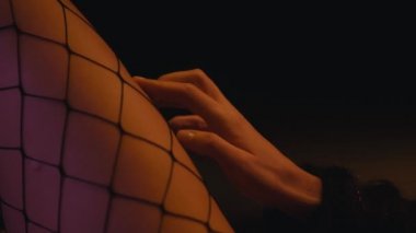 Siyah taytlı, bacağa dokunan kadın görüntüsü. 