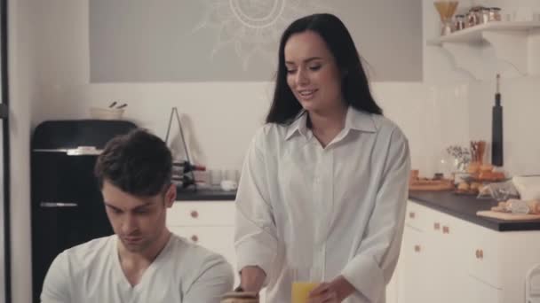 Sexig Kvinna Som Serverar Frukost Nära Frilansare Arbetar Laptop Köket — Stockvideo