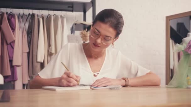 Designer Escrevendo Notebook Perto Manequim Mesa — Vídeo de Stock