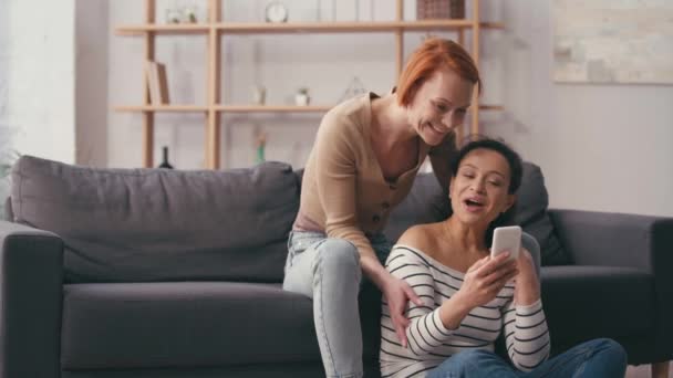 Multicultural Lesbian Couple Looking Smartphone Smiling Living Room — Stock Video