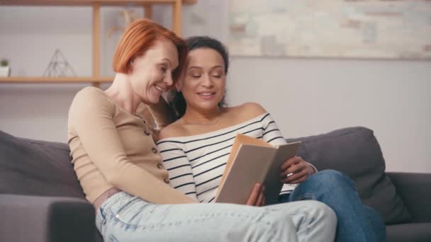 Ισπανίδα Γυναίκα Κρατώντας Βιβλίο Και Μιλώντας Χαρούμενη Φίλη Στο Σαλόνι — Αρχείο Βίντεο