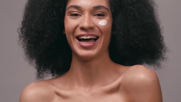 笑着的非洲裔美国女人 脸上的化妆品霜与灰色隔离 — 图库视频影像