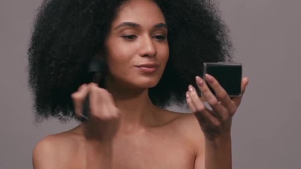 Mujer Joven Afroamericana Aplicando Polvo Facial Aislado Gris — Vídeos de Stock