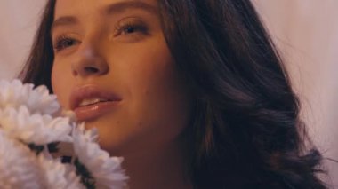 Beyaz çiçekli, şehvetli bir kadının yavaş çekimi. 