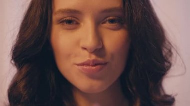 Mutlu esmer, dalgalı saçlı, sus işareti gösteren kadını kapatın.