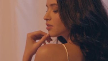 Kıvırcık saçlı, beyaz saçlı, esmer bir kadının yavaş çekimi.