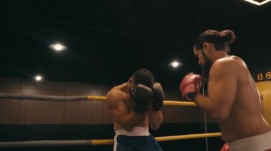 Sakallı boksörün boks ringinde İspanyol rakibini yumruklaması ağır çekimde. 
