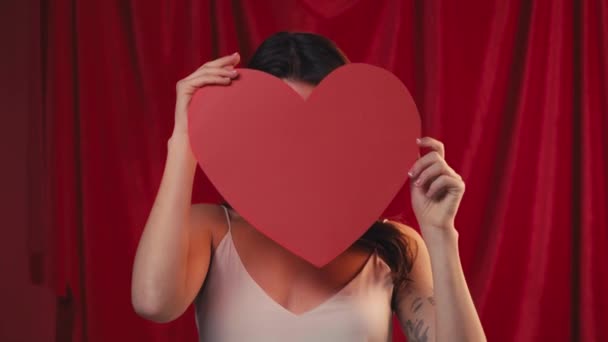 Mutlu Kadın Kağıt Kalple Yüzünü Kaplıyor Kırmızıda Gülümsüyor — Stok video