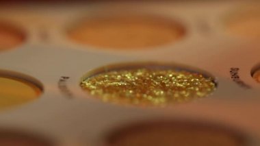 Bir kadının göz farı sürerken parmağında pırıltı var.