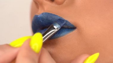 Mavi ruj sürerken taranmış bir kadın görüntüsü 