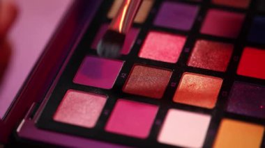 Kozmetik fırçasına pembe göz farı süren bir kadın manzarası