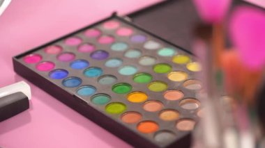 göz farı paleti ve farklı kozmetik fırçaları odakla 