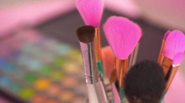 Farklı kozmetik fırçalar ve göz farı paletlerinin raf odağı