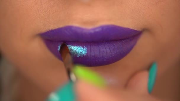 紫色の唇に光沢のある青リップグロスを適用した女性のクロップドビュー — ストック動画