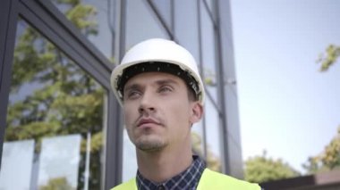 Açık havada yürüyen kasklı bir bina. 