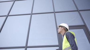 Binanın yanında yürüyen inşaatçının düşük açılı görüntüsü 