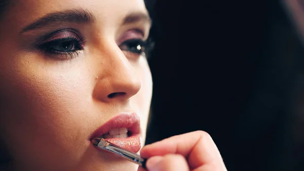 Makijaż Artysta Stosowanie Błyszczące Błyszczyk Usta Modelu Izolowane Czarny — Zdjęcie stockowe