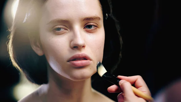 Maquillaje Artista Celebración Cepillo Cosmético Mientras Aplica Base Cara Modelo — Foto de Stock