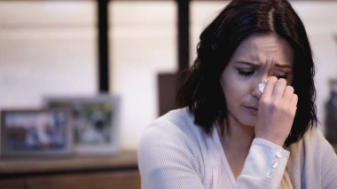 depresif bir kadın evde kağıt peçeteyle gözyaşlarını siliyor.