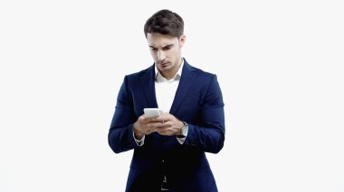 Takım elbiseli genç yönetici beyazda izole edilmiş cep telefonu kullanıyor. 