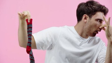 Burnunu kapatan ve pembe çorabını tutan iğrenç adam.