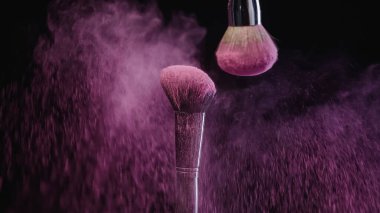 yumuşak kozmetik fırçalar siyah arka planda pembe holi boyası lekeleri