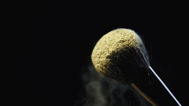 Sarı holi tozu yumuşak kozmetik fırçasında siyah renkte izole edilmiş 