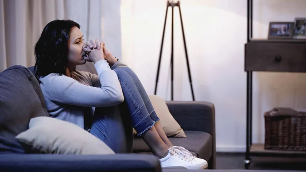 Depressed Woman Casual Clothes Sitting Sofa Holding Clenched Hands Mouth — Stock Photo, Image