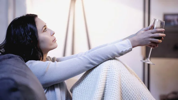 Upprörd Kvinna Täckt Filt Sitter Soffan Med Glas Vin Utsträckta — Stockfoto